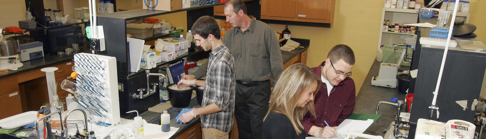 photo of a professor and students working in a lab